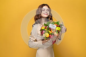 pretty woman beige coat fruit bouquet in hands present isolated background