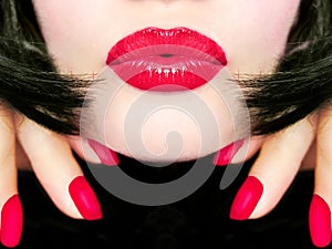 pretty woman with black hair, red lips and fingernails sending a kiss / smooch