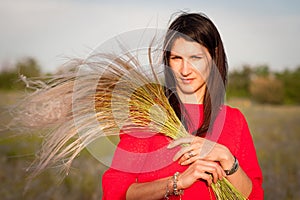 Pretty woman with bouquet of grass