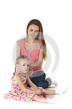 Pretty woman brushing her daugther's hair against