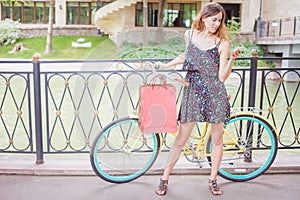 Pretty woman with bugs using mobile phone near vintage bicycle