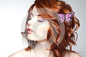 Pretty woman with a butterfly in her red hair - beauty shot