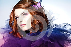 Pretty woman with a butterfly in her red hair - beauty shot