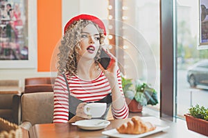 Pretty woman chatting with friends while coffee break at cafe, smiling and looking at window