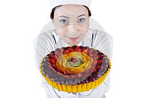 Pretty woman chef holding a dessert cake
