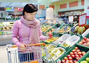 Pretty woman choosing apple at fruit supermarket