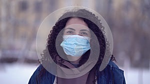 Pretty woman in a city wearing face mask protective for spreading of disease virus SARS-CoV-2