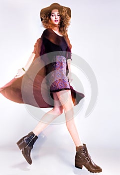 Pretty woman with curly hair dressed casual posing in the studio