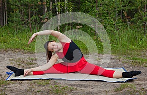 Pretty woman doing yoga exercises in the woods