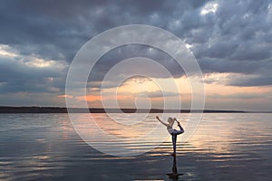 Pretty woman doing yoga at sunset outdoors