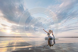 Pretty woman doing yoga at sunset outdoors