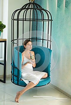 Pretty woman drink japanese tea in iron cage. perfect morning with coffee. matcha tea ceremony of girl in cage chair