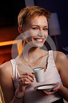 Pretty woman drinking coffee in cosy room