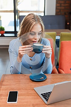 pretty woman drinking coffee while looking