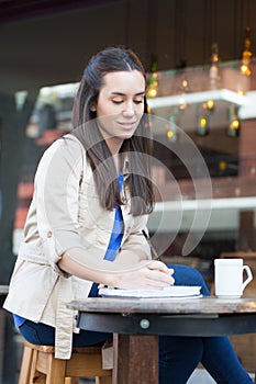 Pretty woman drinking coffee in the street