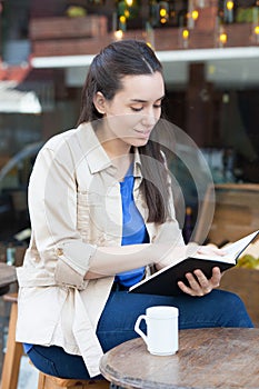 Pretty woman drinking coffee in the street