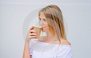 Pretty woman drinking coffee takeaway. Girl drinks Espresso, latte, cappuccino in paper cup.