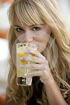 Pretty woman drinking a glass of orange juice