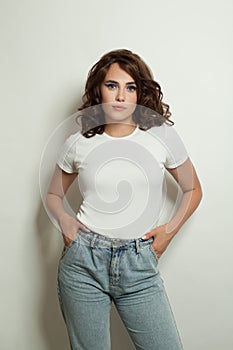 Pretty woman in empty white t-shirt standing on white background