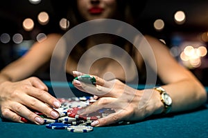pretty woman in evening black dress plays poker in the casino