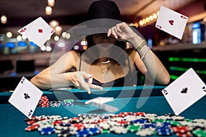 pretty woman in evening black dress plays poker in the casino