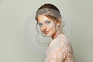 Pretty woman with fashionable hairdo and pastel makeup on white background