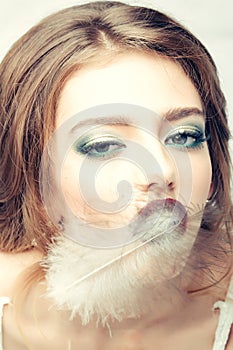 Pretty woman with feather closeup