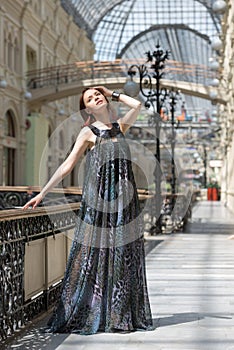 Pretty woman in a flutter transparent cape at old fashioned building
