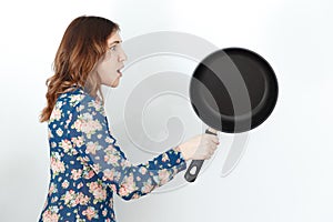 Pretty woman with frying pan, humor on 8 march