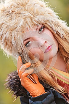 Pretty woman in fur hat talking on mobile phone.