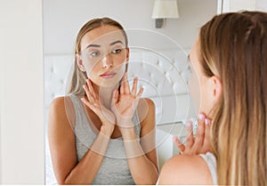 Pretty woman,girl touching her neck while looking in the mirror, beauty and fashion concept,wrinkles