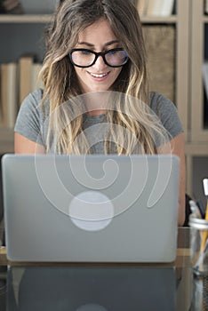 Pretty woman with glasses eyewear work at home on laptop computer - smart working female people at office desk