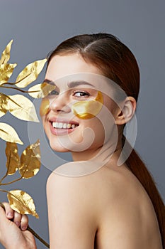 pretty woman golden leaves luxury skin care face patches bare shoulders close-up Lifestyle