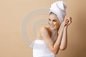 pretty woman golden patches on the face with a towel on the head close-up Lifestyle