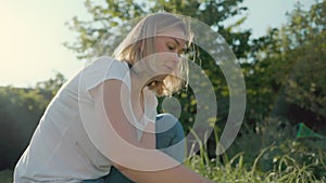 Pretty woman harvests lettuce from the garden. Sunset light. Jib shot. Slow motion. Gardening season concept