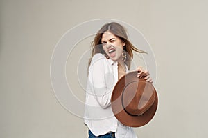 Pretty woman hat in hand white shirt style attractive look light background