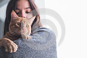 Pretty woman holding and looking at a cat