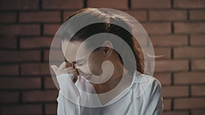 Pretty woman laughing and hiding smile with hands while video shooting in studio