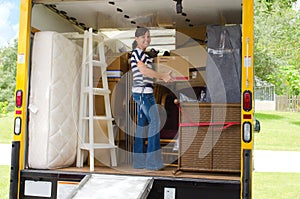 Pretty woman loading a full moving truck