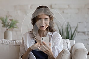 Pretty woman looks at smartphone screen smile read pleasant sms