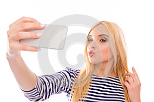 Pretty woman making selfie on her smartphone and pouting