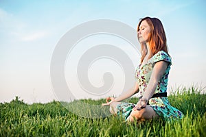 Pretty woman meditate in the park