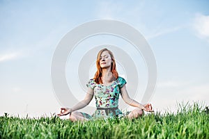 Pretty woman meditate in the park