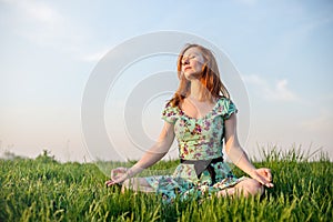 Pretty woman meditate in the park