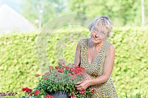 A pretty woman of middle age care flowers
