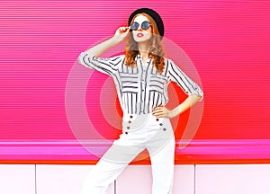 Pretty woman model wearing a black hat sunglasses white pants