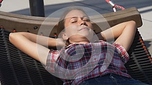 Pretty woman napping in hammock in city park