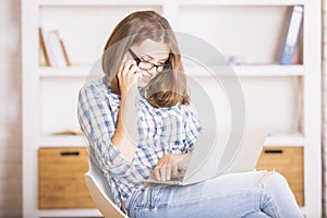 Pretty woman on phone using laptop