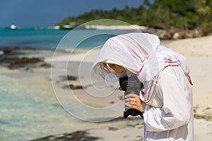 Pretty woman is a photographer with slr camera