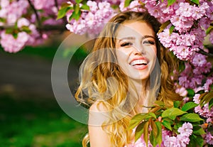 Pretty woman in pink blossom park. Happy young girl with smiling face enjoy spring.